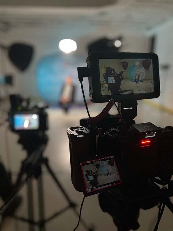 Corporate video filming setup with camera, lighting, and crew